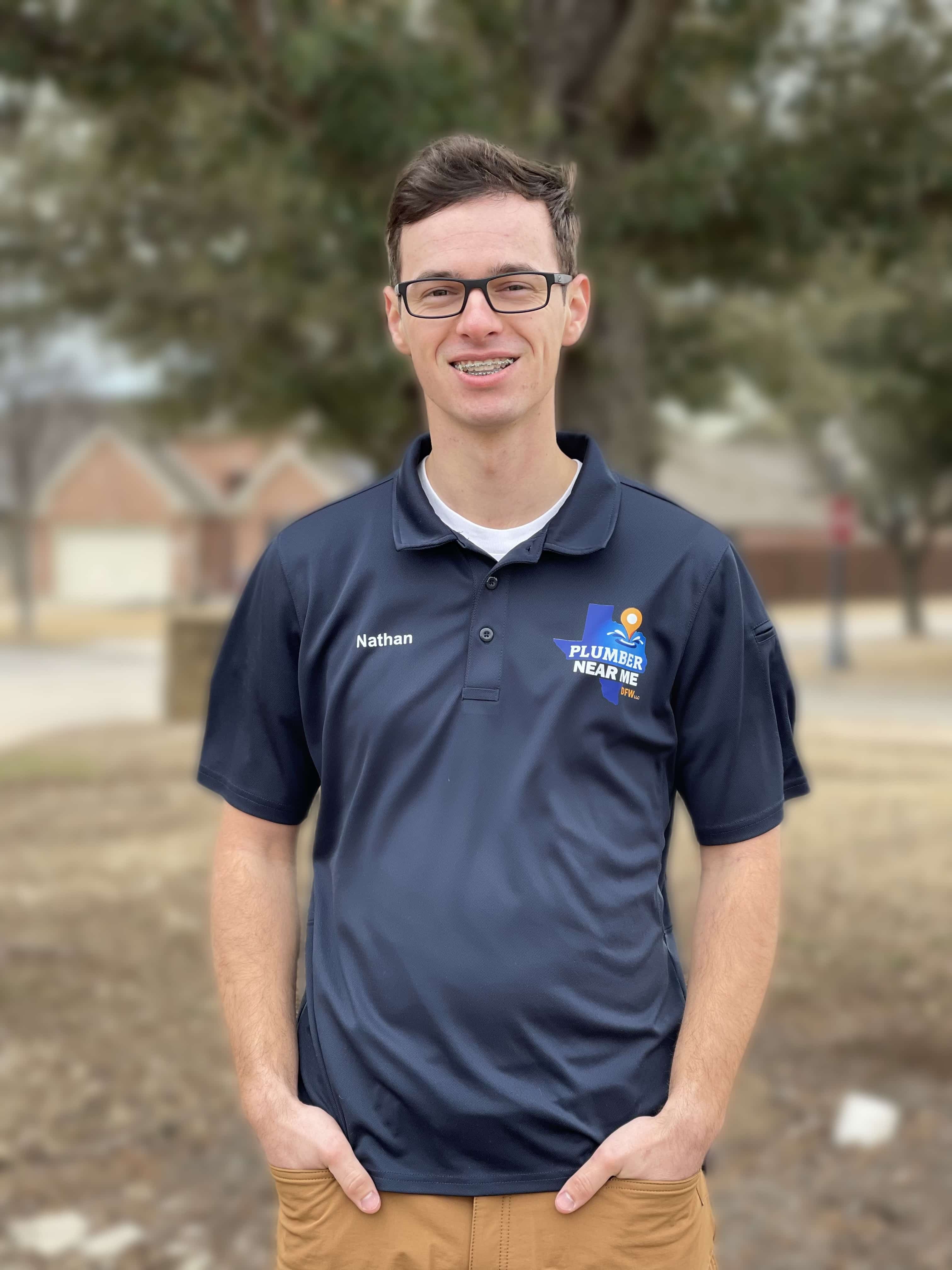 Plumber Near Me DFW team member in branded polo shirt, standing outdoors, showcasing expertise in plumbing services for Azle, North Richland Hills and Fort Worth, TX.